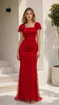 Front view of model wearing a ruby red beaded square neck floor-length evening gown with flutter cap sleeves