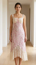 Model wearing pink floral midi dress with lace trim from the front