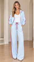 Front view of model wearing light blue striped track jacket and matching wide-leg pants set